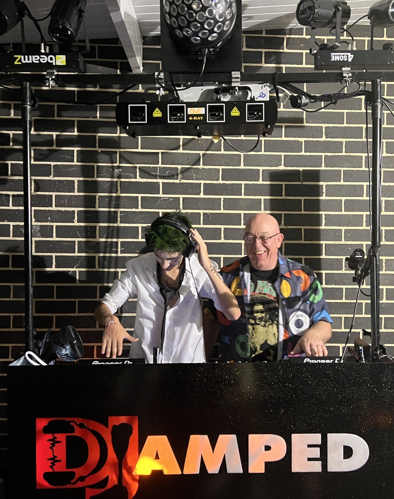 A party guest trying the DJ headphones beside AMPT Australia