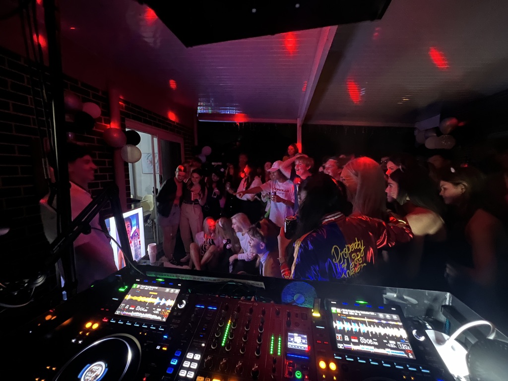 Party guests gathered under red dance-floor lighting