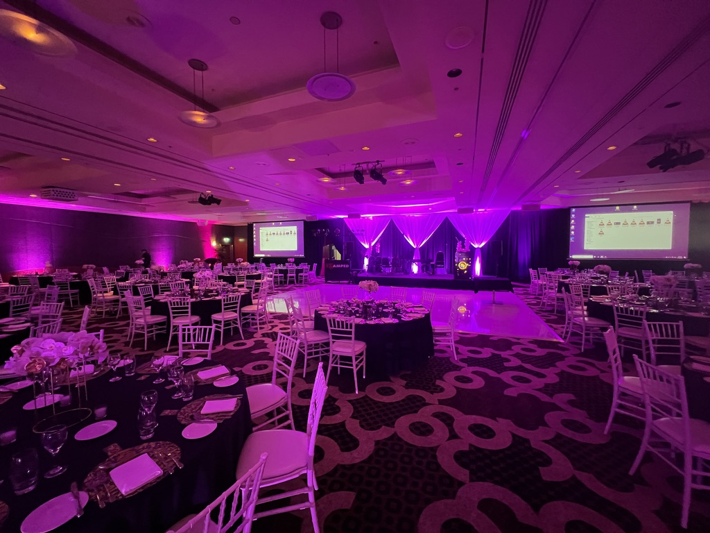 Ballroom prepared in purple lighting for The Disability Trust’s 50th anniversary
