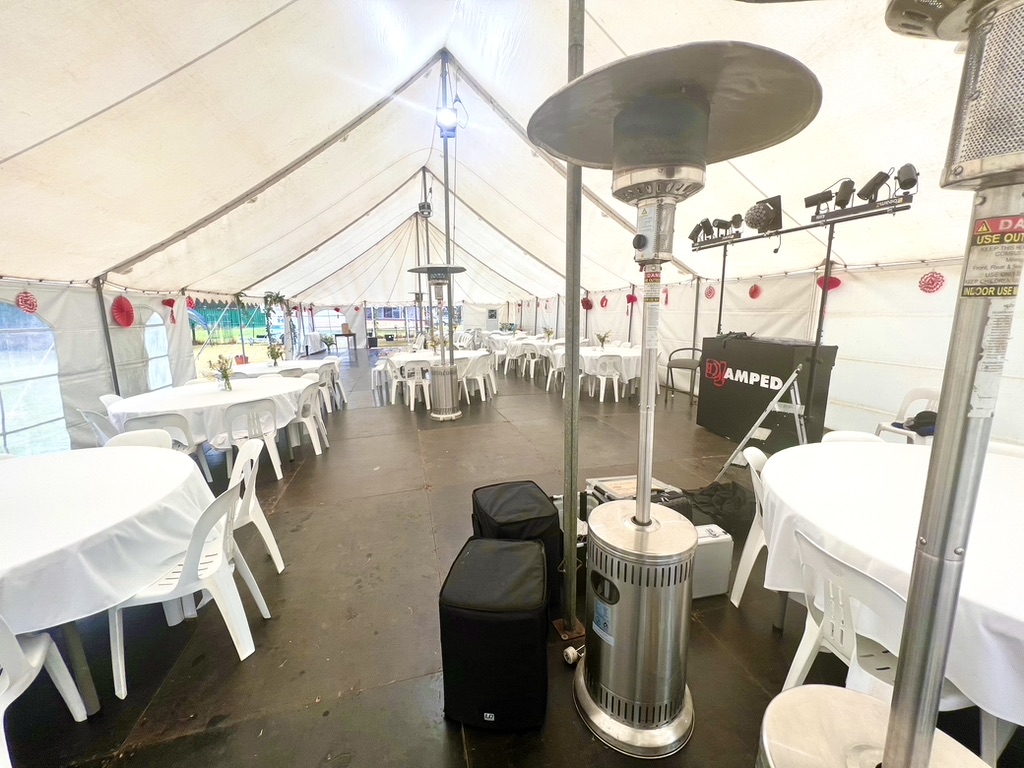 Wide view of the wedding marquee with tables, heaters and AMPT booth