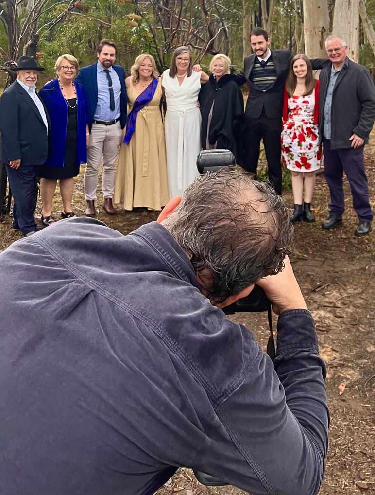 Wedding photographer capturing a group portrait in the bushland