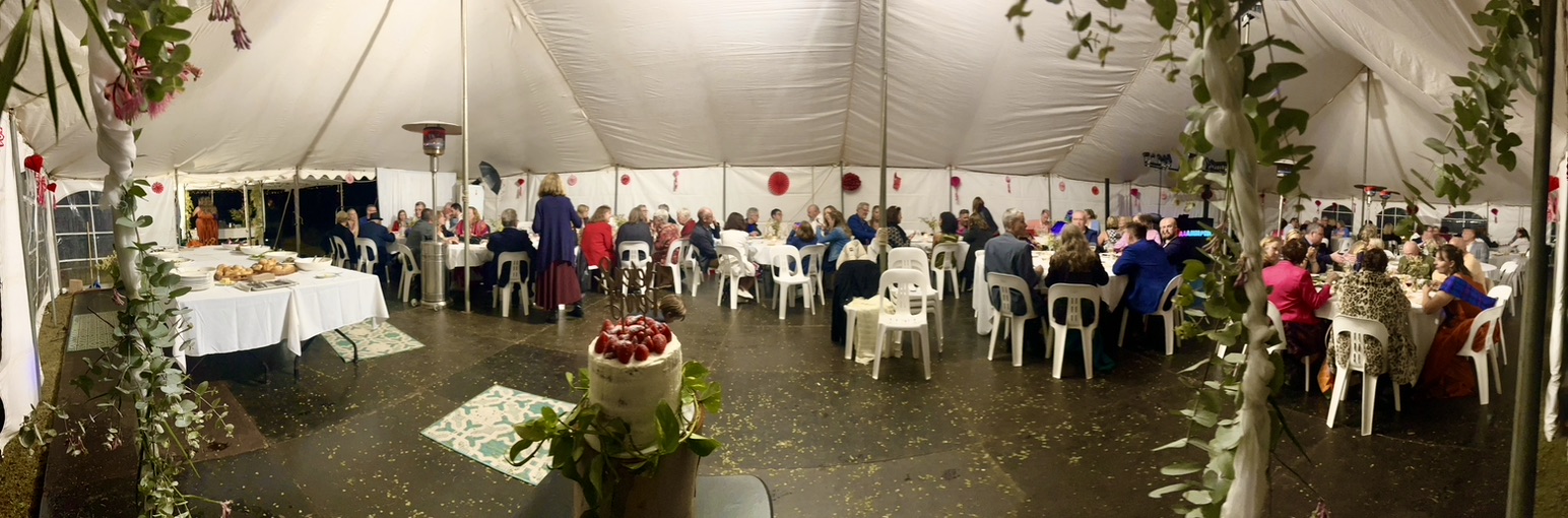 Panoramic view of guests dining inside the wedding marquee
