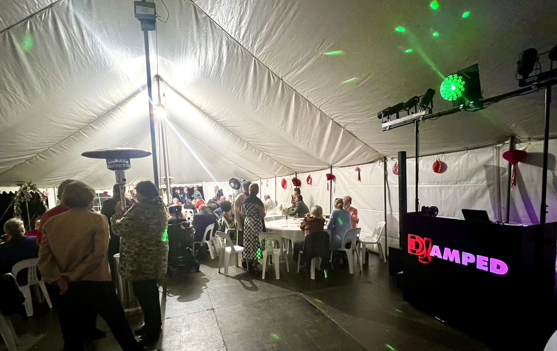 Wide view of the AMPT booth and guests beneath green lighting