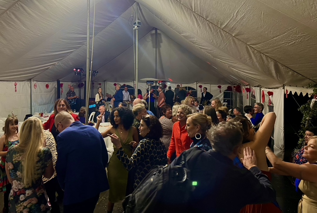 A busy wedding dance floor inside the marquee