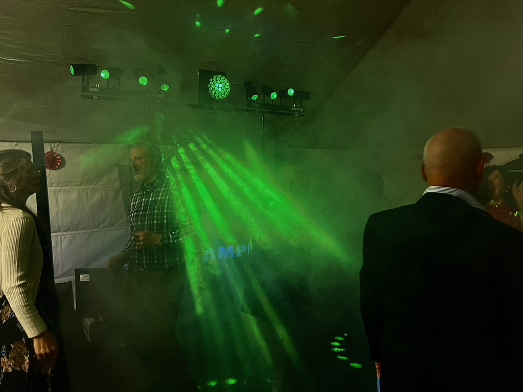 Green AMPT lighting beams crossing the marquee dance floor