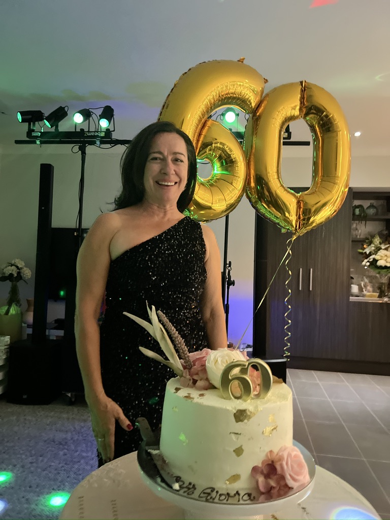 Birthday guest with her cake and gold 60 balloons
