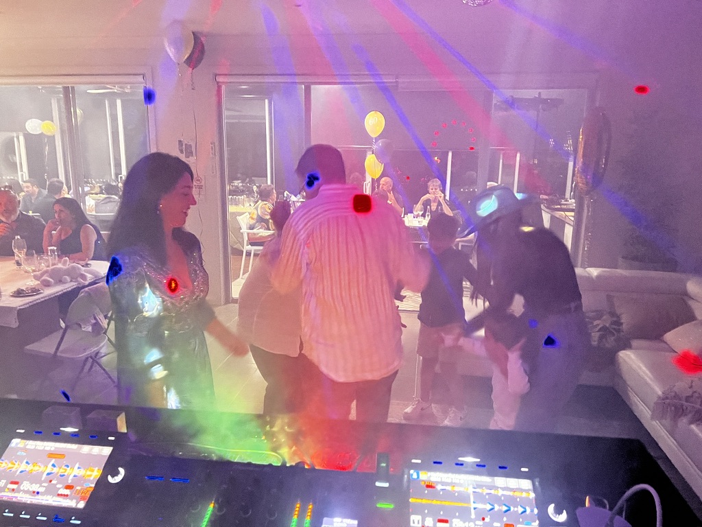 Guests dancing in coloured beams during the home birthday