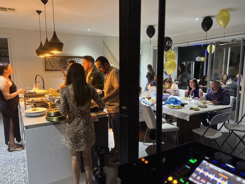 Birthday guests gathering around the kitchen and dining tables