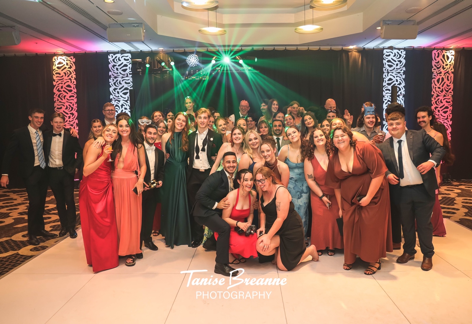 Guests gathered on the dance floor beneath green lighting with AMPT Australia at the DJ setup