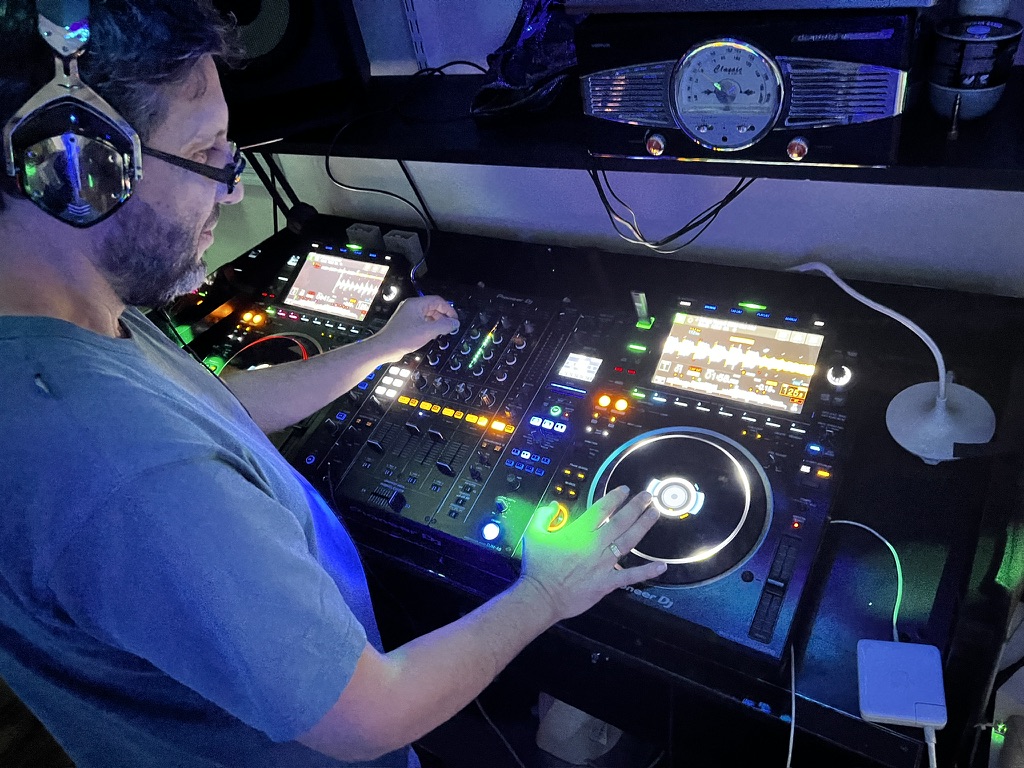 An adult student practising a mix across the full Pioneer DJ setup