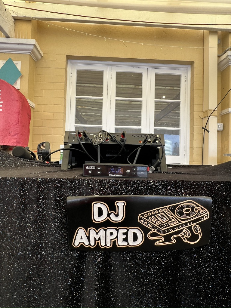 DJ AMPED sign on the black DJ booth
