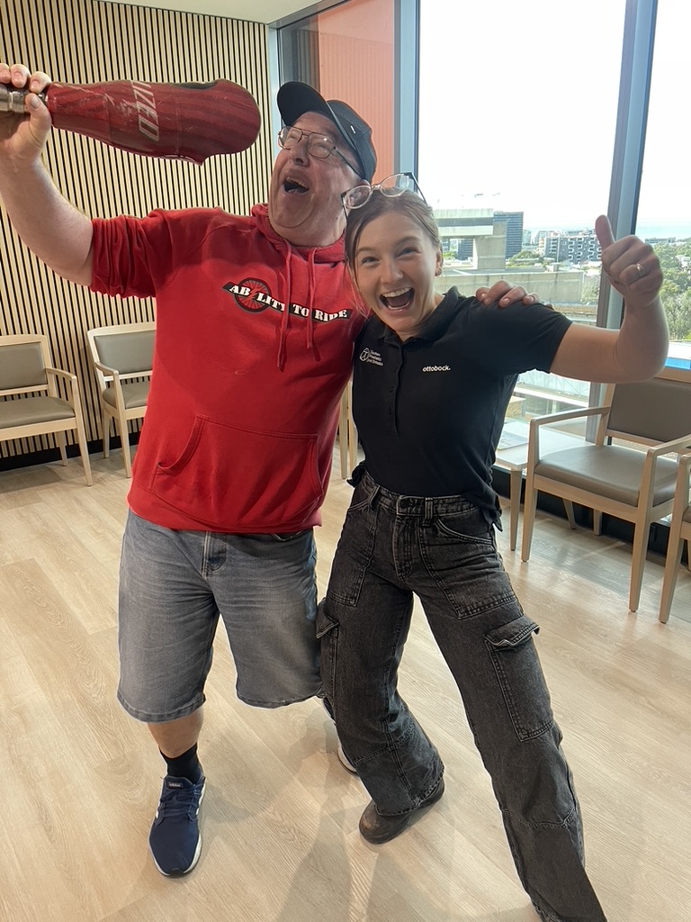 AMPT Australia celebrating with his prosthetist and holding an old prosthetic leg