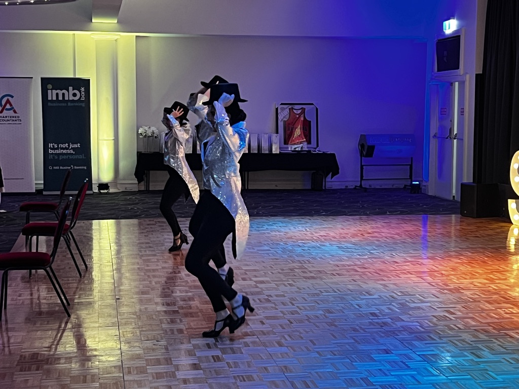 Showtime dancers performing under blue and gold lighting