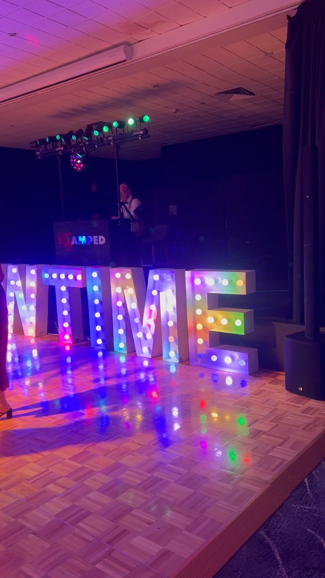 AMPED DJ booth behind purple illuminated Showtime letters