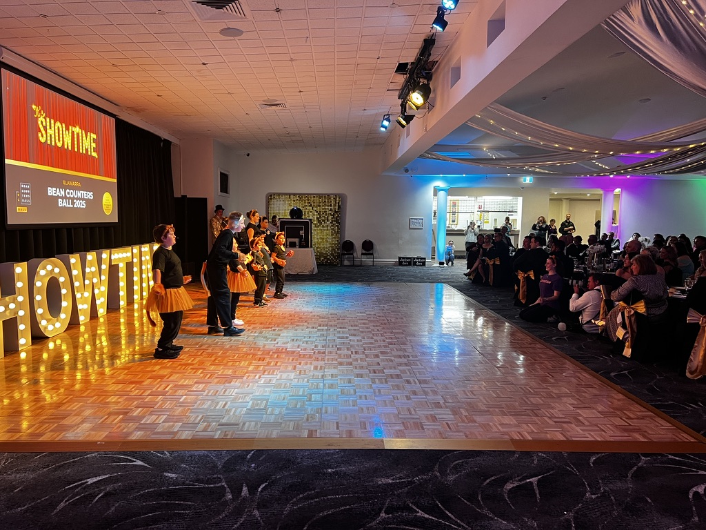 Performers dancing for seated fundraiser guests