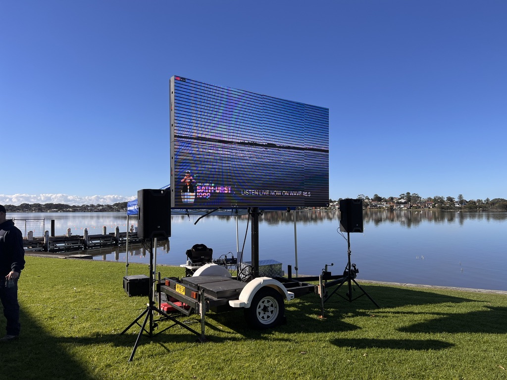 Outdoor event screen and speakers beside the lake