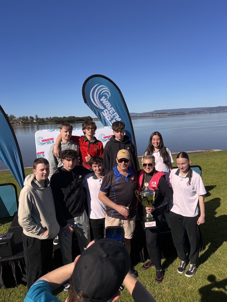 Group posing with a trophy at the Wave FM event