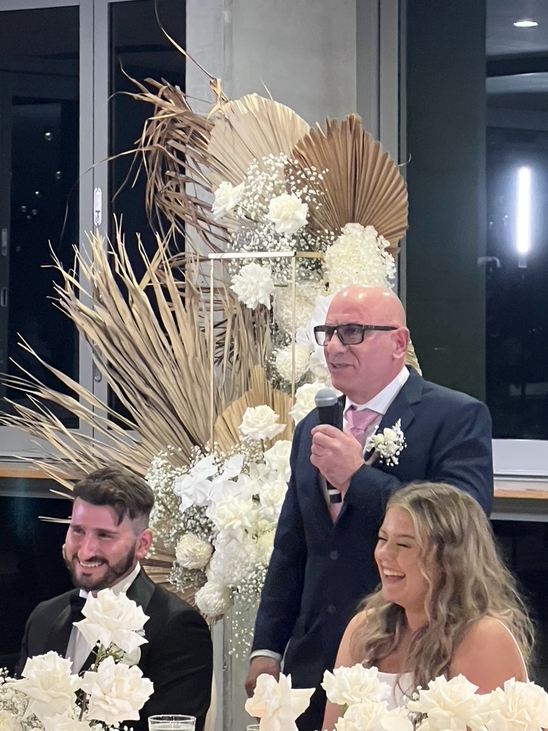 Jonathan and Caitlin laughing during a wedding speech