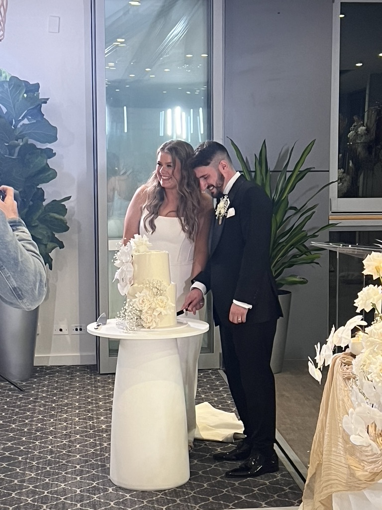 Jonathan and Caitlin cutting their wedding cake together